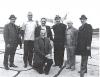 Alberta Bishops at an airfield in Fort Smith: (left to right) Bishop Paul Piche, Archbishop MacNeil, Bishop Martin Grechuk, Bishop Raymond Ray kneeling, Bishop Neil Savaryn, Bishop Paul O'Byrne, and Archbishop Henri Legare.