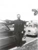 Monsignor Allen Reynolds standing beside a car