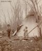 Three Aboriginal children standing in front of a tee-pee