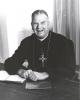 Archbishop Jordan sitting at a desk in his office smiling