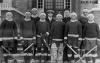 Seminarians in hockey uniforms with hockey sticks